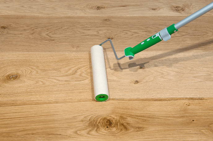 Applying Osmo Polyx Oil to an oak floor using a roller and tray