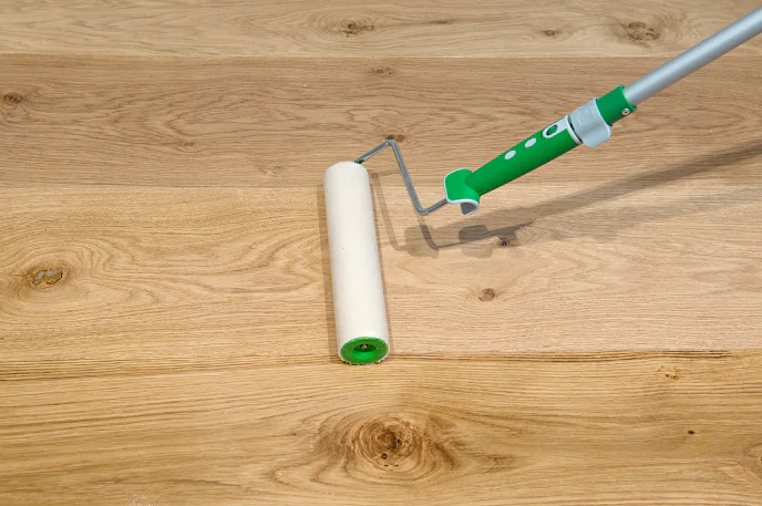 Applying Osmo Polyx Oil to an oak floor using a roller and tray